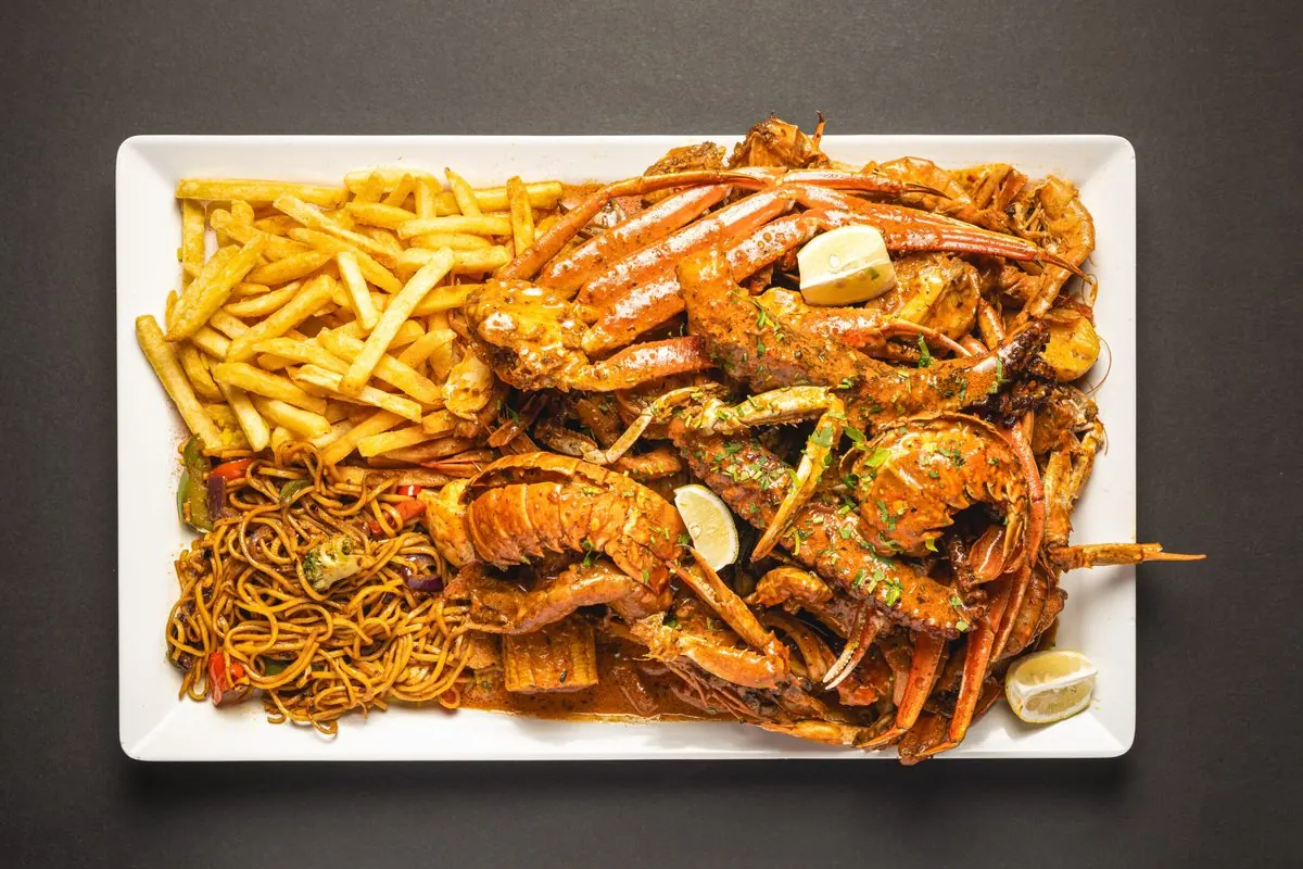 A seafood boil of snow crab, lobster and shrimp in rich sauce, with chips and noodles